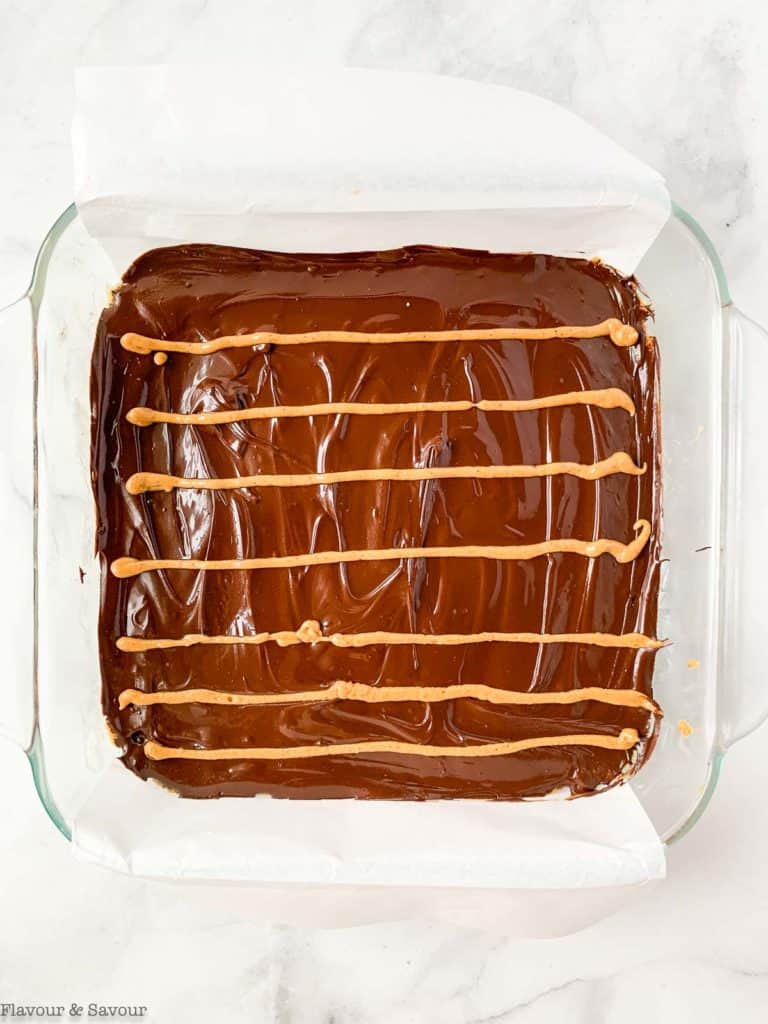 Adding lines of peanut butter to chocolate topping