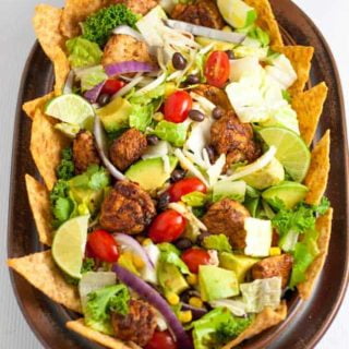 Skinny Chopped Chicken Taco Salad. Lean taco seasoned chicken breast cubes, crispy romaine, black beans, corn, tomatoes, red onions, creamy avocados and Monterey Jack cheese, tossed with a lime vinaigrette and served with taco chips. |www.flavourandsavour.com