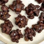 Chocolate cashew clusters on a plate.