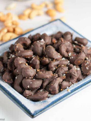 a serving dish with chocolate covered cashews with sea salt