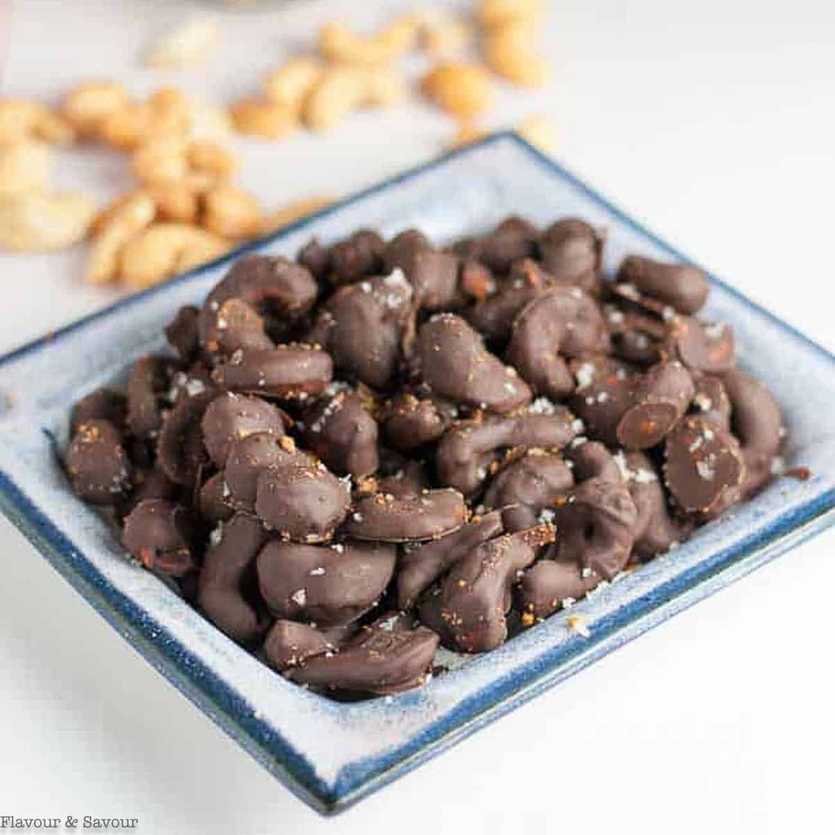 A serving dish with chocolate covered cashews with sea salt.