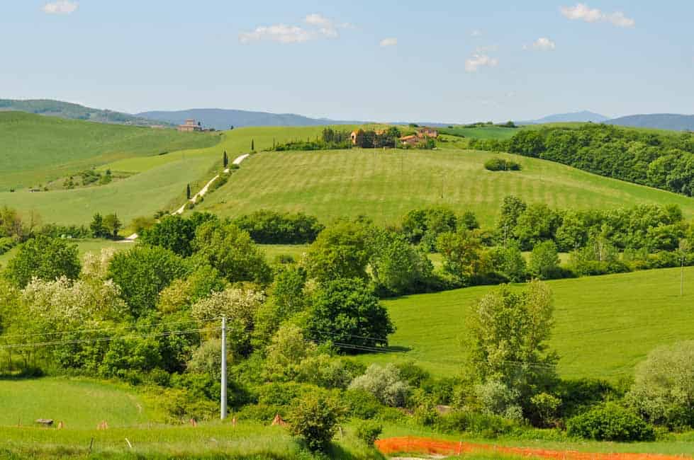 Tuscan hillside view with rolling hills and an agritourismo.