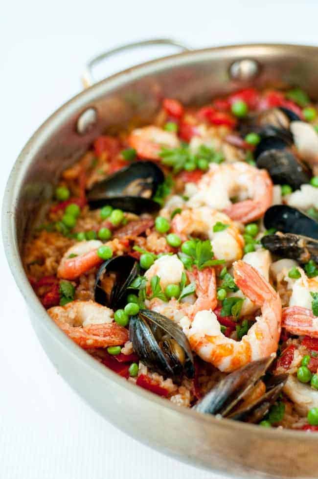 a paella pan with seafood paella