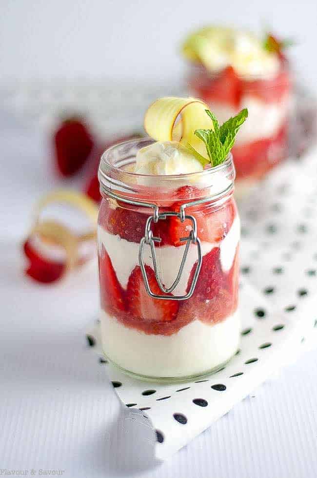  skinny strawberry rhubarb parfait in a glass jar garnished with mint and a curl of rhubarb
