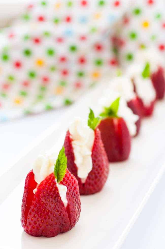 Sweet Goat Cheese Stuffed Strawberries with Mint in a row 