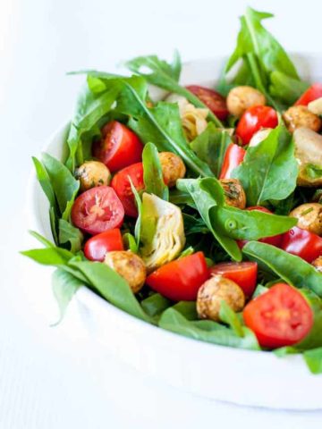 Balsamic Bocconcini Cherry Tomato Salad with Marinated Artichokes and Arugula. This vegetarian salad packs a punch of flavour. Peppery arugula , balsamic bocconcini balls , marinated artichokes and fresh cherry tomatoes combine to make a salad I could eat every day! |www.flavourandsavour.com