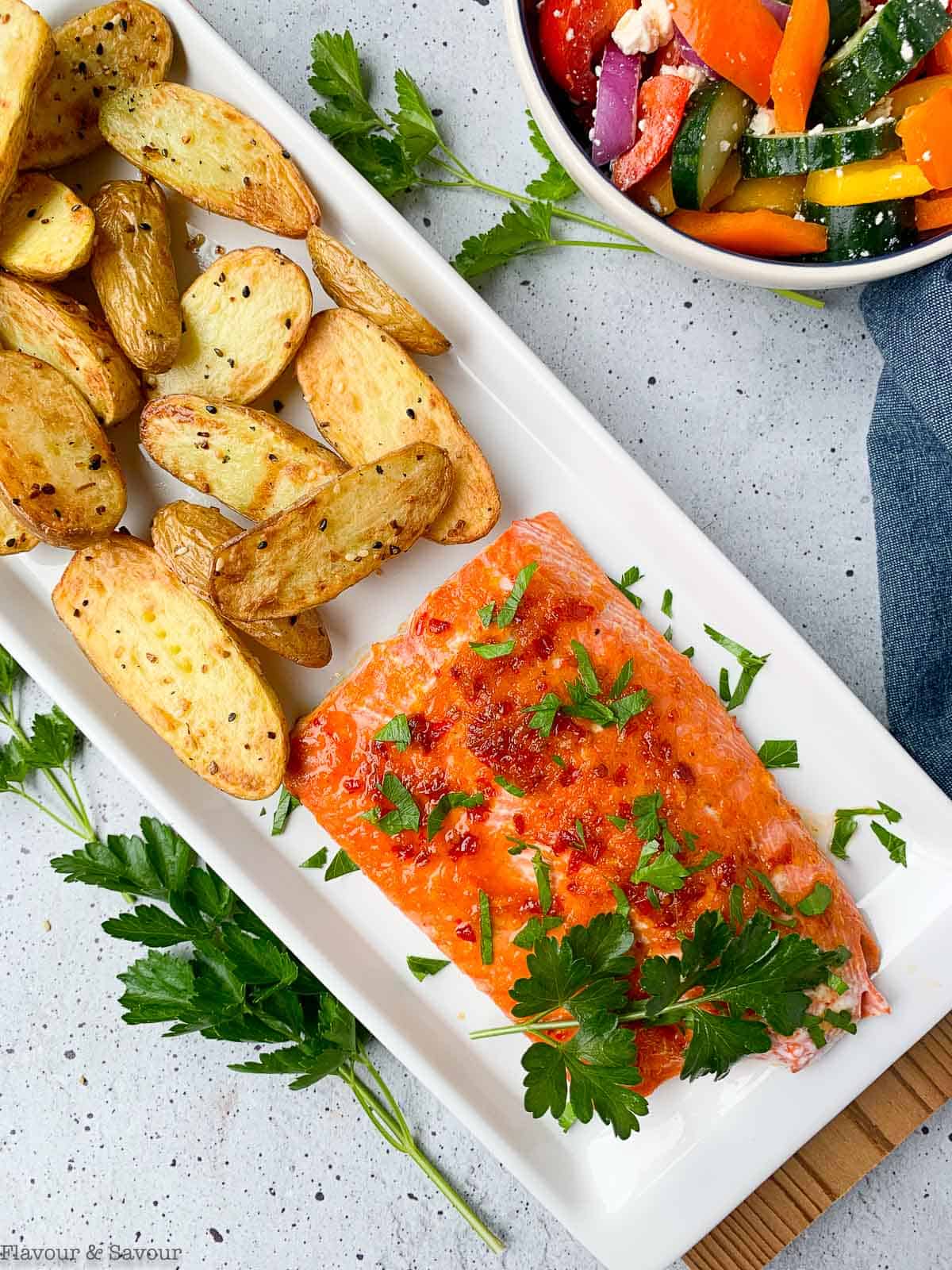 Overhead view of Citrus Chardonnay Glazed Wild Salmon on a platter with fingerling potatoes.