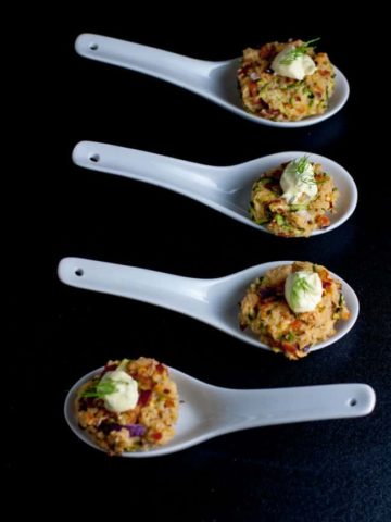 Crispy Smoked Salmon Zucchini Cakes on white porcelain spoons