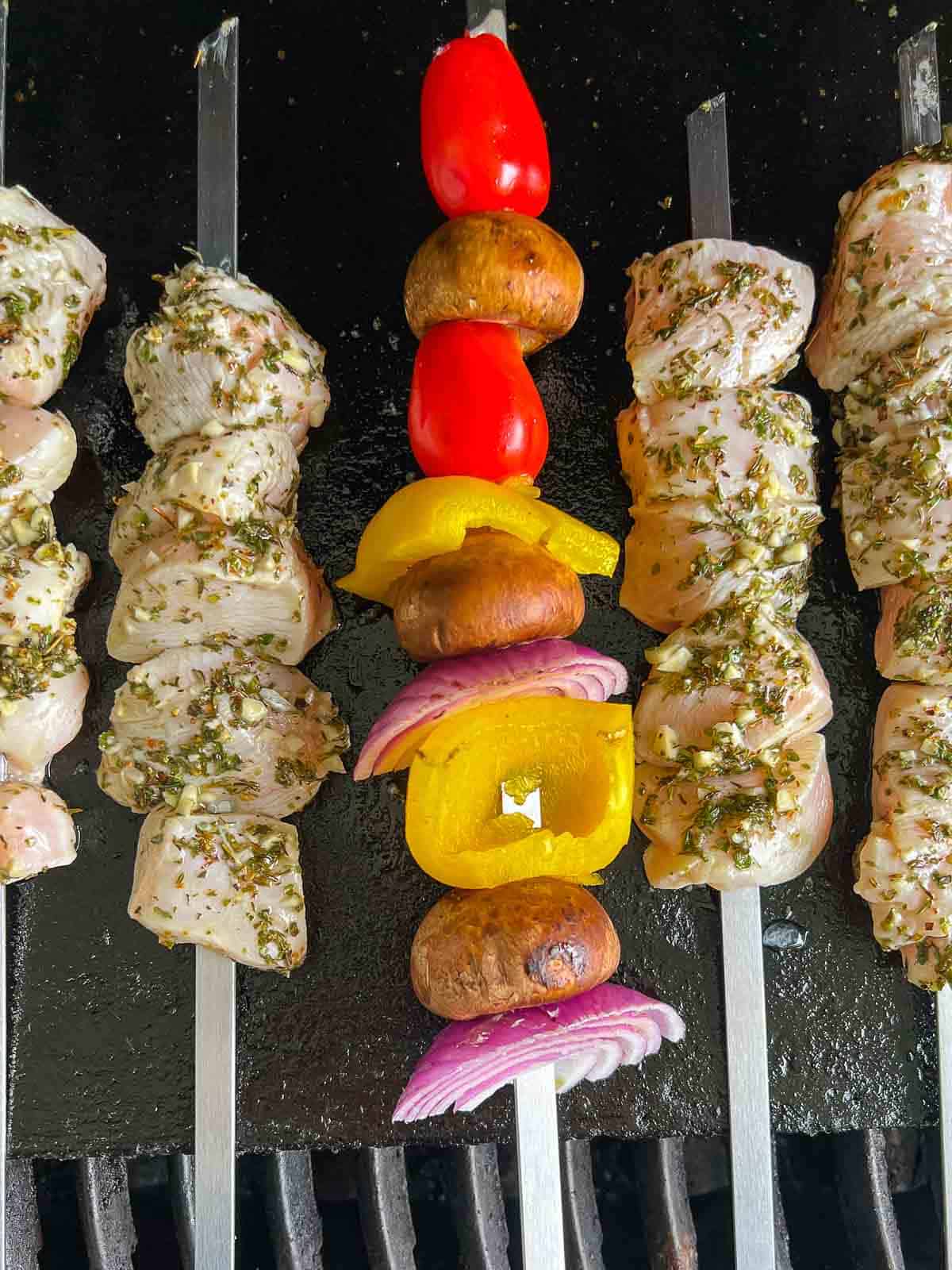 Greek chicken kabobs on an outdoor grill.