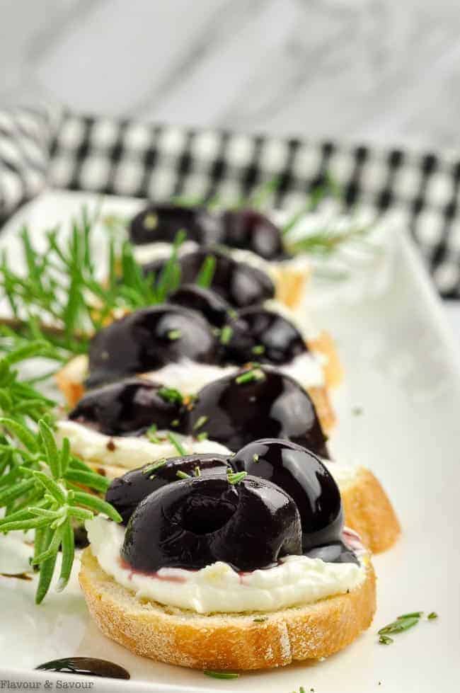 Roasted Cherry Whipped Goat Cheese Crostini garnished with fresh rosemary sprigs