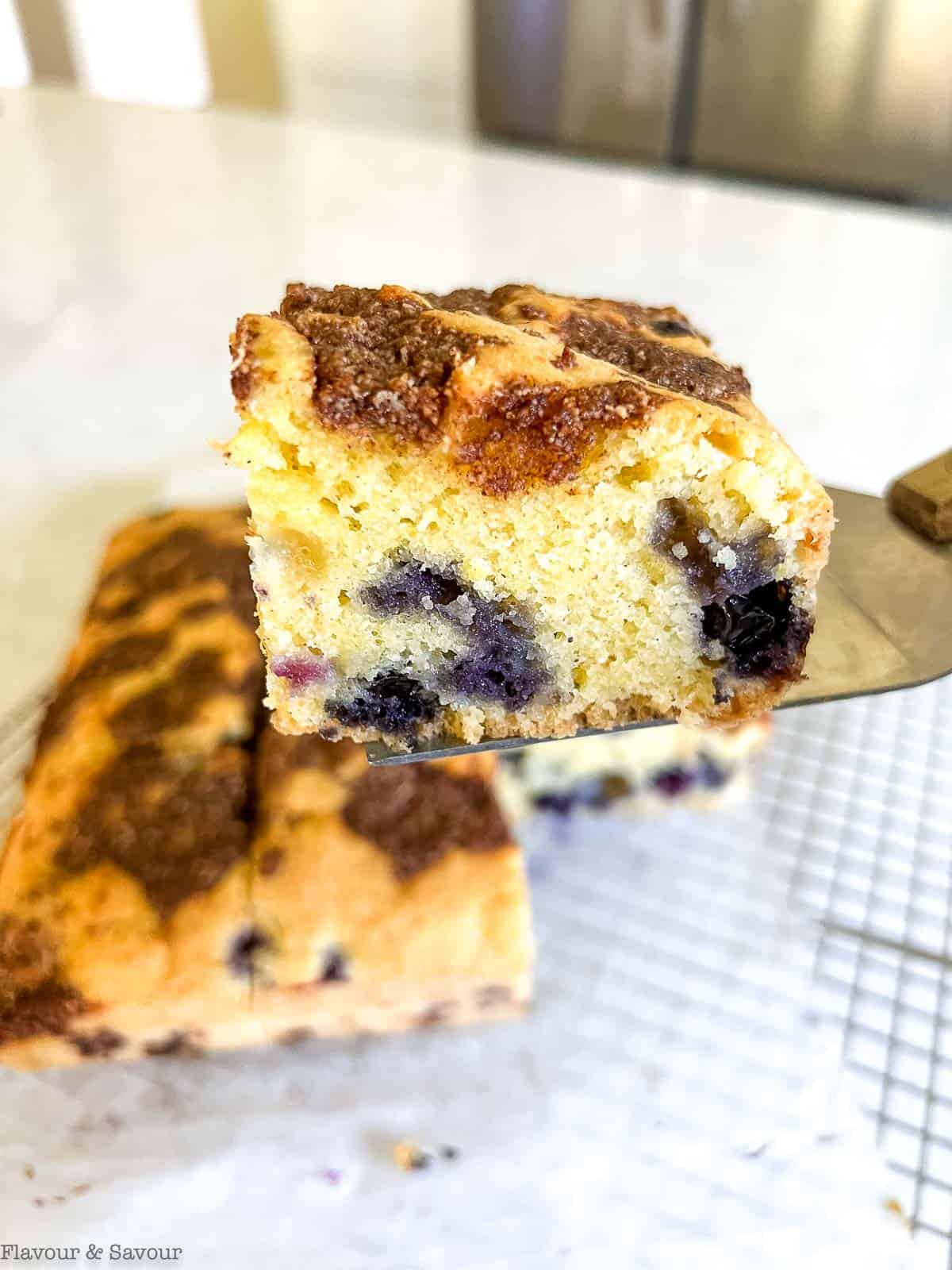 Close up view of a slice of gluten-free blueberry lemon coffee cake.