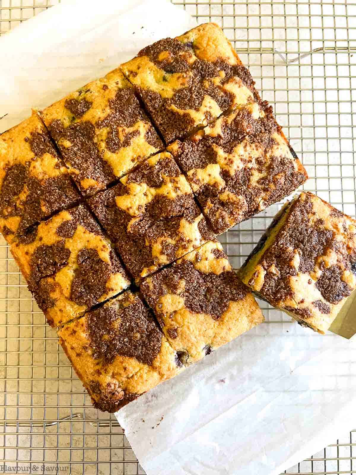 Overhead view of a baked blueberry lemon coffee cake on a cooling rack.