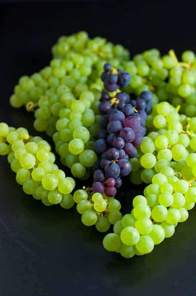 Green and purple Concord grapes.