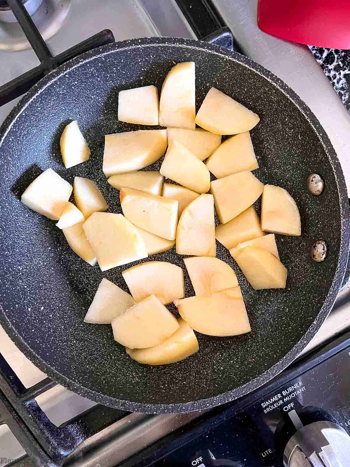 Chopped apple pieces in a small skillet.
