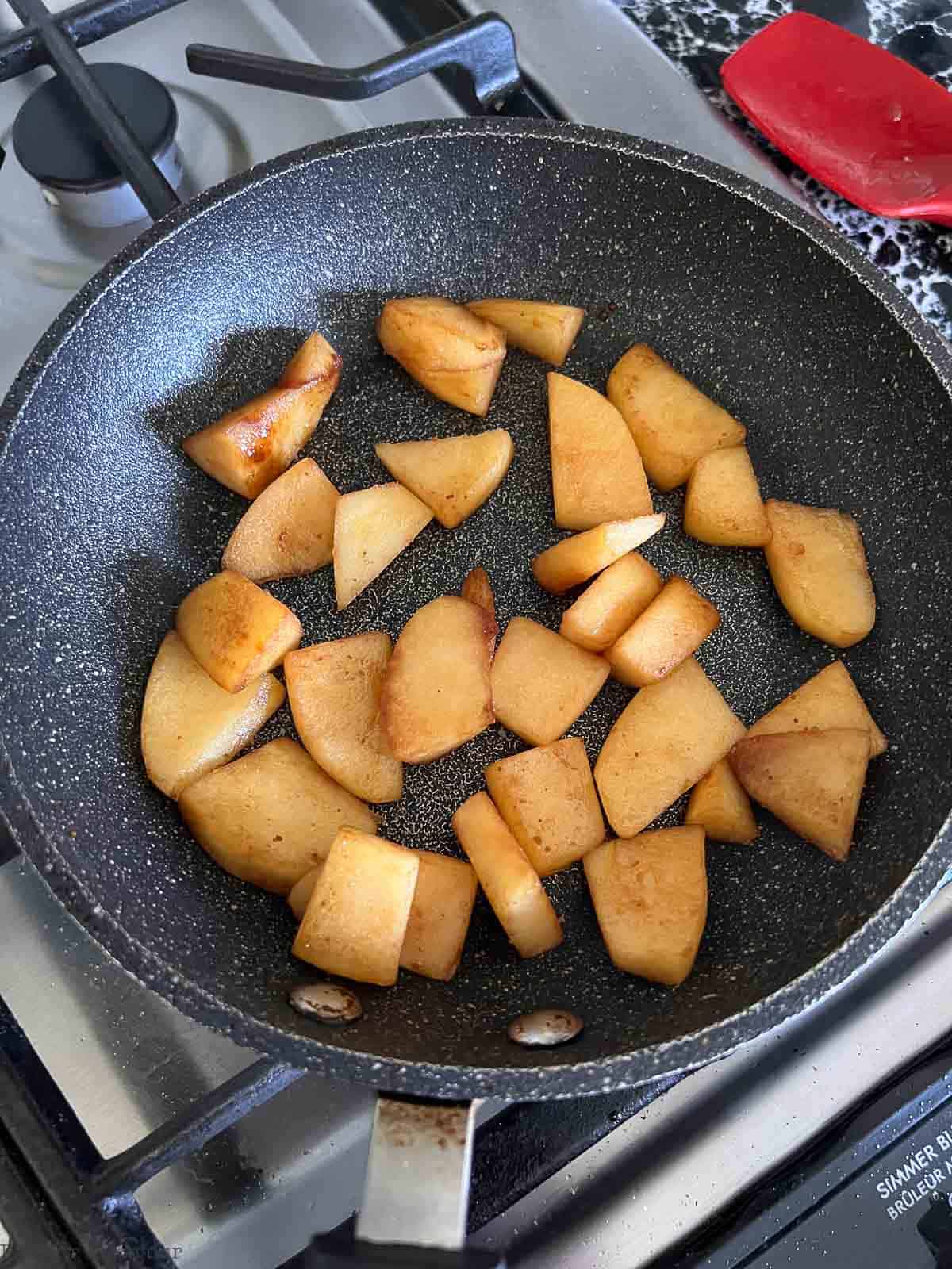 Caramelized apple pieces in a small skillet.