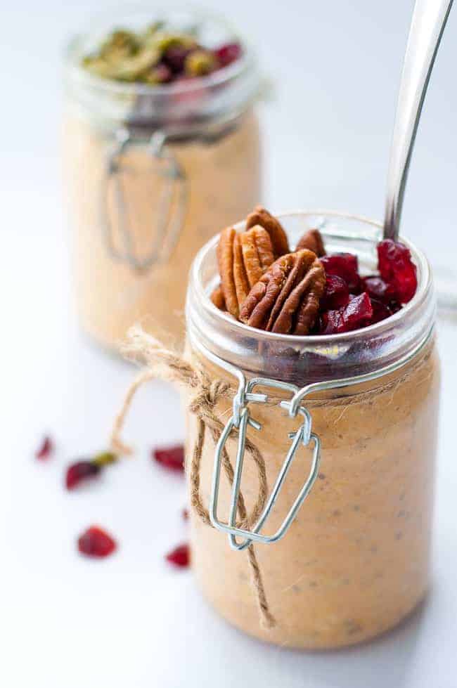 Creamy Pumpkin Pie Overnight Oats topped with pecans and cranberries in a jar.