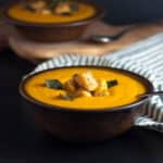 two bowls of chipotle sweet potato soup with polenta croutons