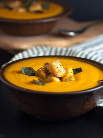 two bowls of chipotle sweet potato soup with polenta croutons