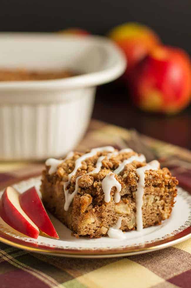 Gluten-Free Apple Cinnamon Coffee Cake drizzled with frosting and served with apple slices.