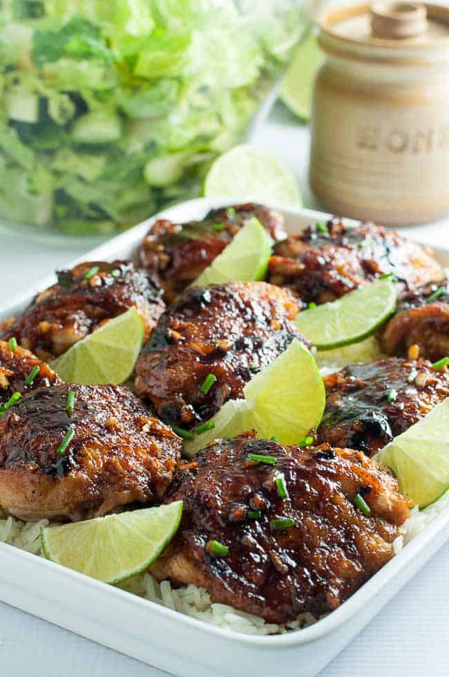 Honey Lime Chicken Thighs on a platter with lime slices.