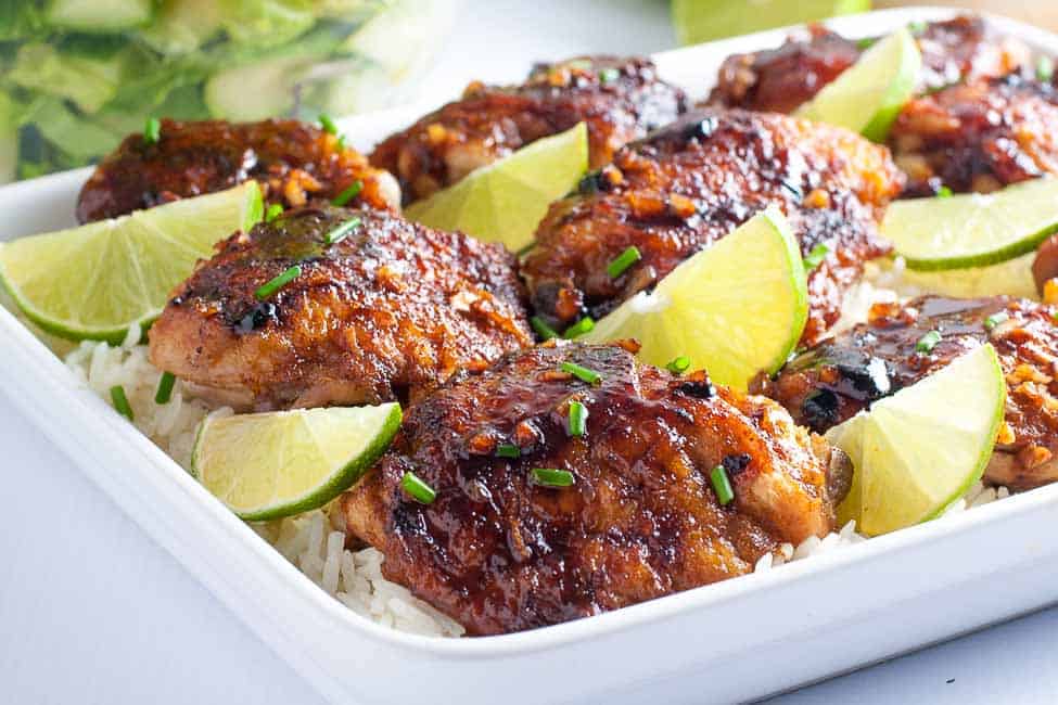 Honey Lime Chili Chicken Thighs in a white dish with slices of lime