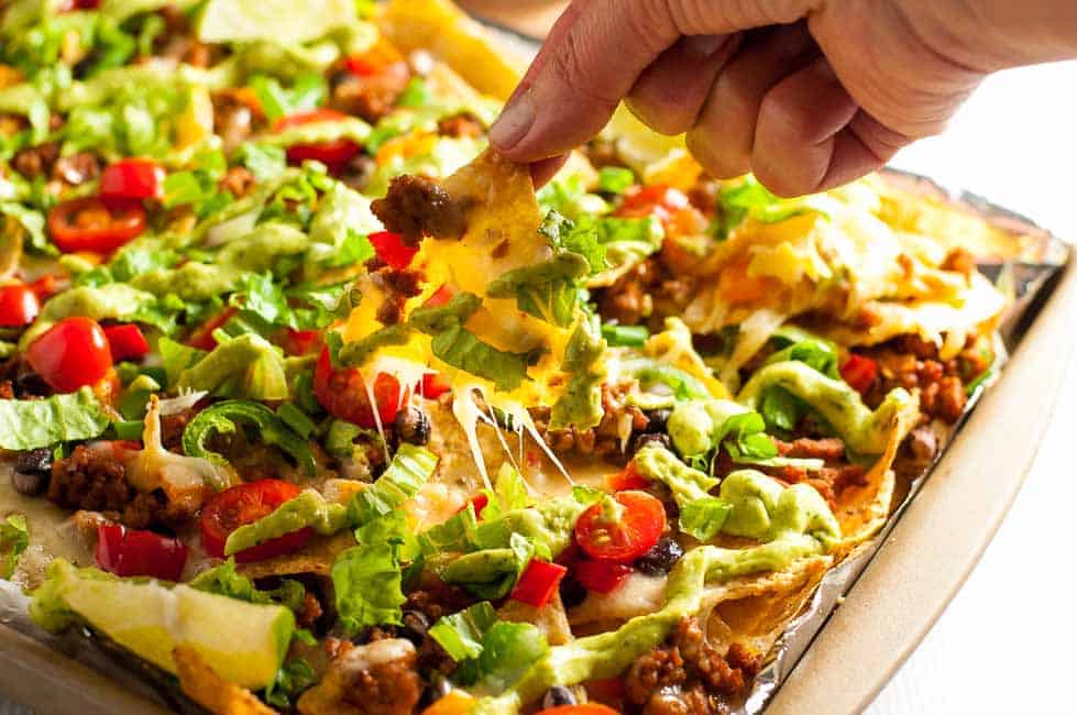 Loaded Sheet Pan Nachos with Black Beans and Avocado Cream. 