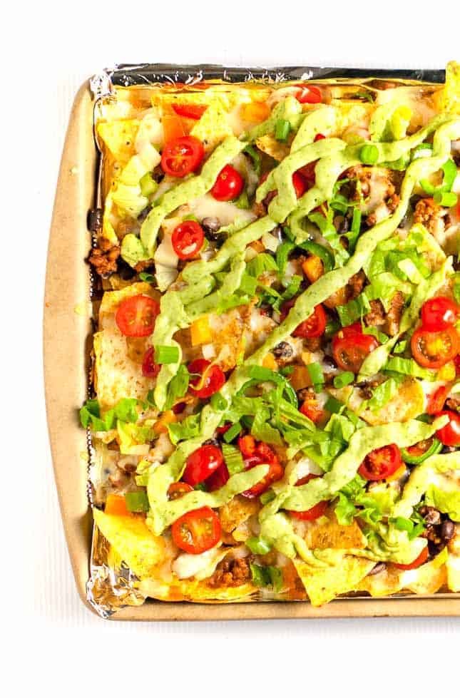 These Loaded Sheet Pan Nachos have it all. Crispy chips, ooey-gooey cheese, spicy chicken, creamy avocado, and lots of crunchy veggies--a perfect combo! |www.flavourandsavour.com