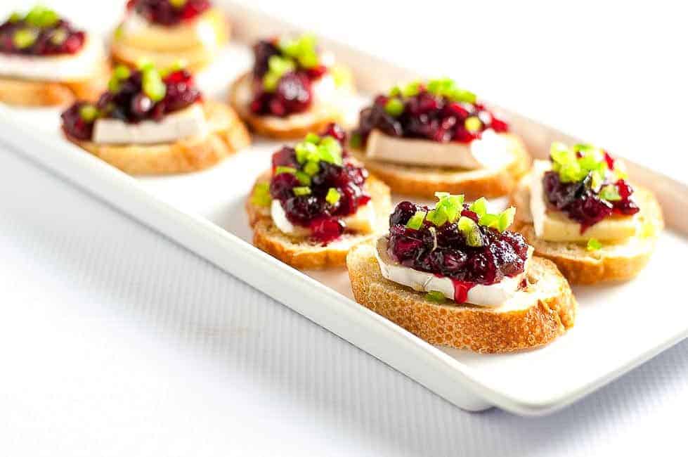 These Cranberry Jalapeño Brie Crostini Appetizers add a festive touch to your party and they're a great way to use leftover cranberry sauce! |www.flavourandsavour.com