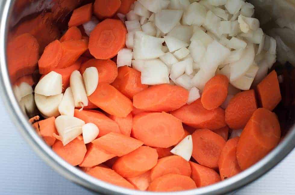 Slow Cooker Sweet Potato Turmeric Soup (Instant Pot). Instant Pot Bowl filled with sweet Potatoes, carrots, onions and garlic 