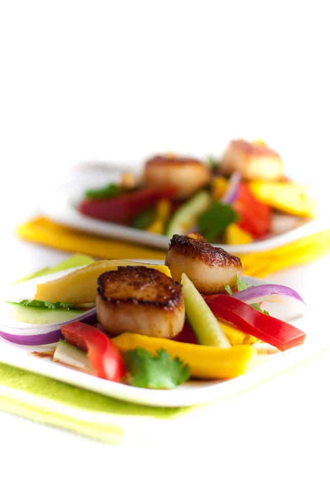 Seared Scallops with Mango Salad. Discover three simple steps to create perfectly seared scallops, and serve them on a colourful salad made with thinly sliced mango, red pepper, cucumber and red onion.