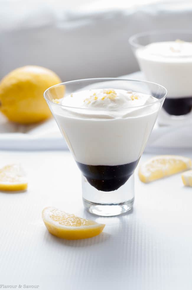 Light Lemon Mousse with Blueberry Sauce in a glass serving dish with lemon slices.