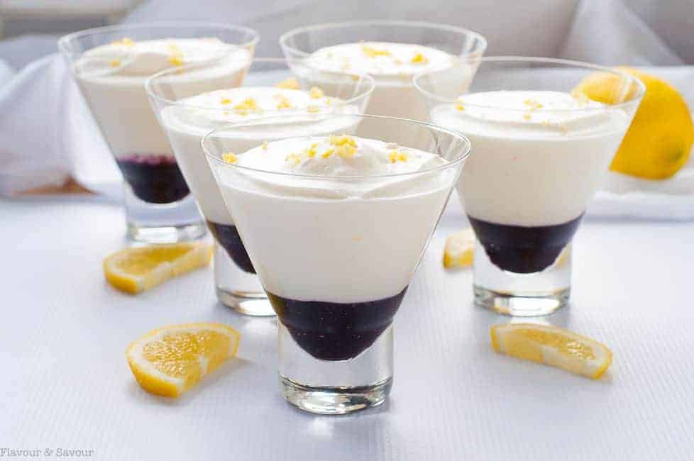 Light Lemon Mousse with Blueberry Sauce in dessert cups, garnished with lemon zest.