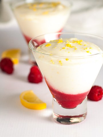 Square image of light lemon mousse with raspberry sauce.