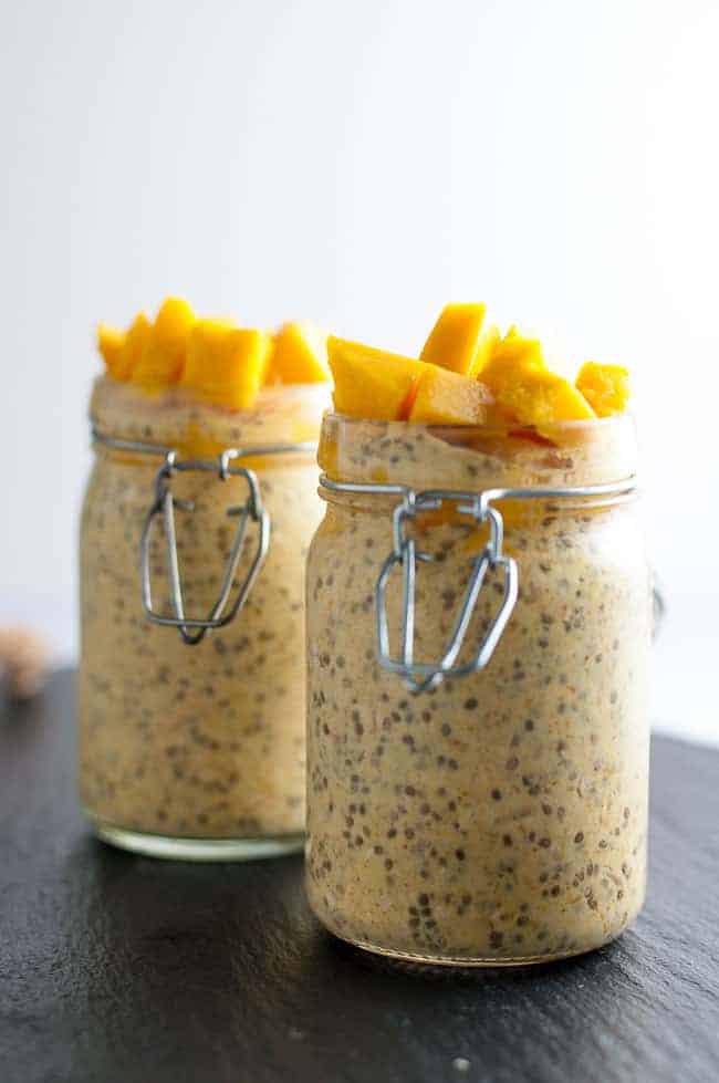 Mango turmeric Kefir Overnight Oats in jars with diced mango on top.