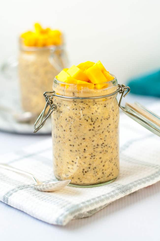 Two jars of Mango Turmeric Overnight Oats topped with fresh diced mango
