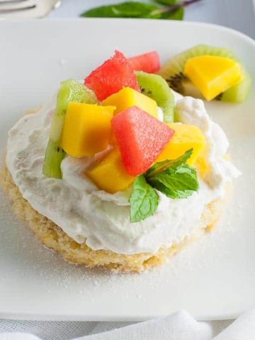 Gluten Free Lemon Fruit Flan on a plate with mango and melon