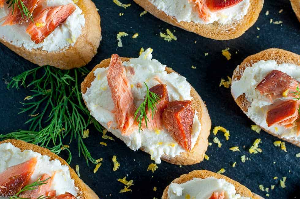 Smoked Salmon Crostini with Whipped Honey Lemon Goat Cheese on a black background