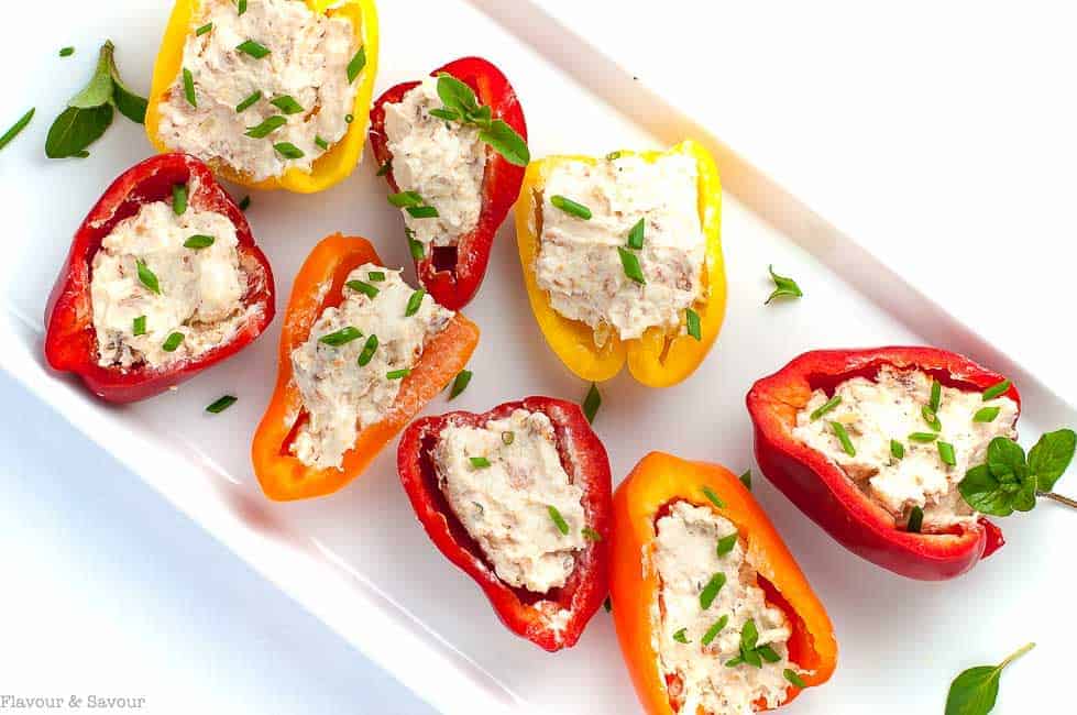 \ Sun-dried Tomato, Artichoke and Cheese Stuffed Mini Peppers on a white platter.