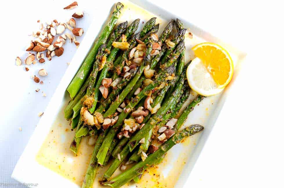 Charred Asparagus with Warm Citrus Sauce on a white platter.