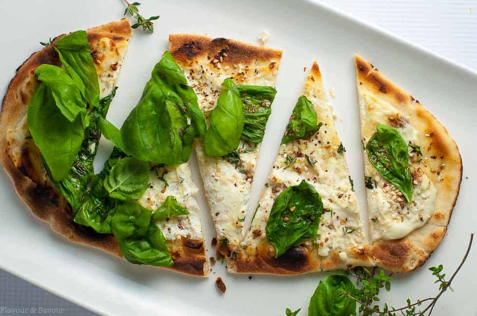 Whipped Goat Cheese Sesame Flatbread with fresh basil leaves