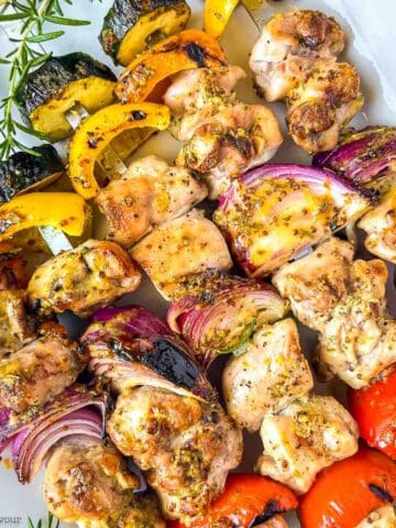 Grilled rosemary mustard chicken kabobs on skewers.