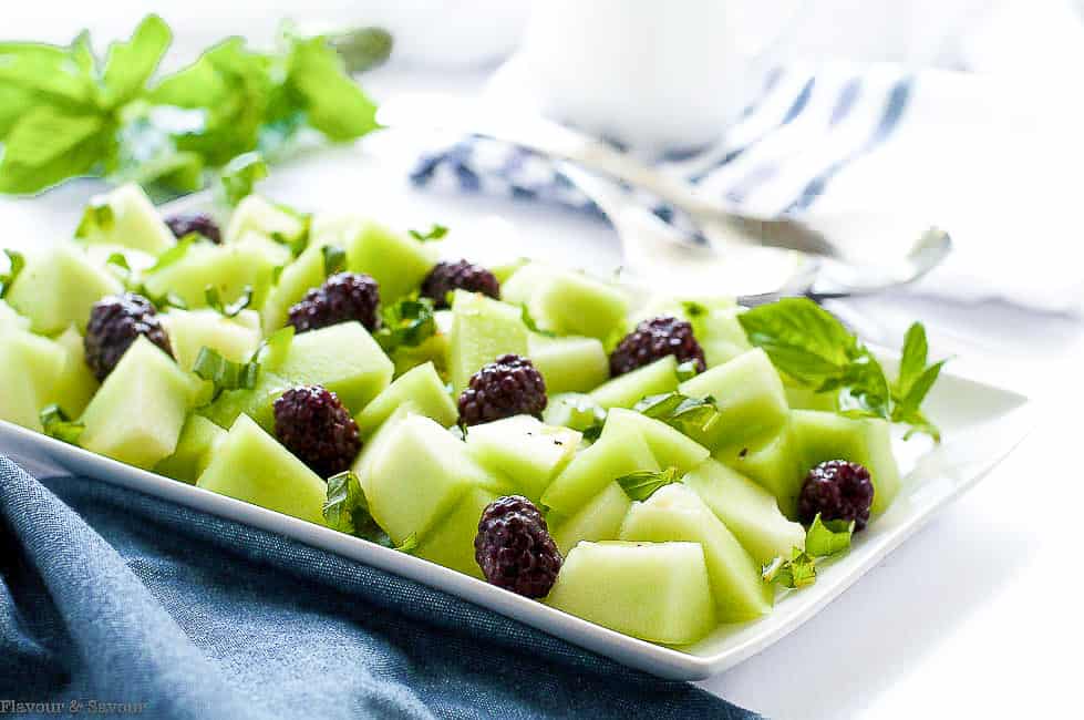 Blackberry Honeydew Melon Salad on a white serving plate with a blue cloth