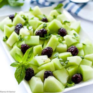 close up view of Blackberry Honeydew Salad with fresh basil leaves