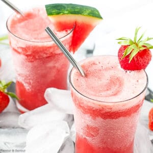 Two glasses of strawberry watermelon sangria slushie with straws.