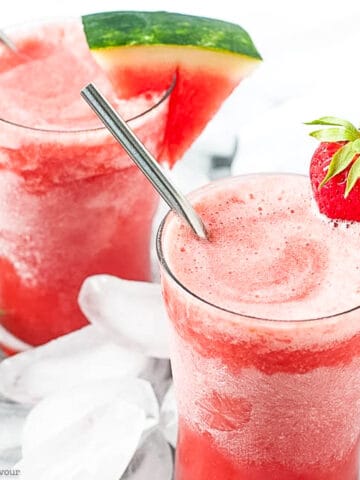 Two glasses of strawberry watermelon sangria slushie with straws.