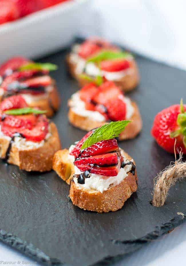A platter with strawberry whipped feta crostini appetizers.
