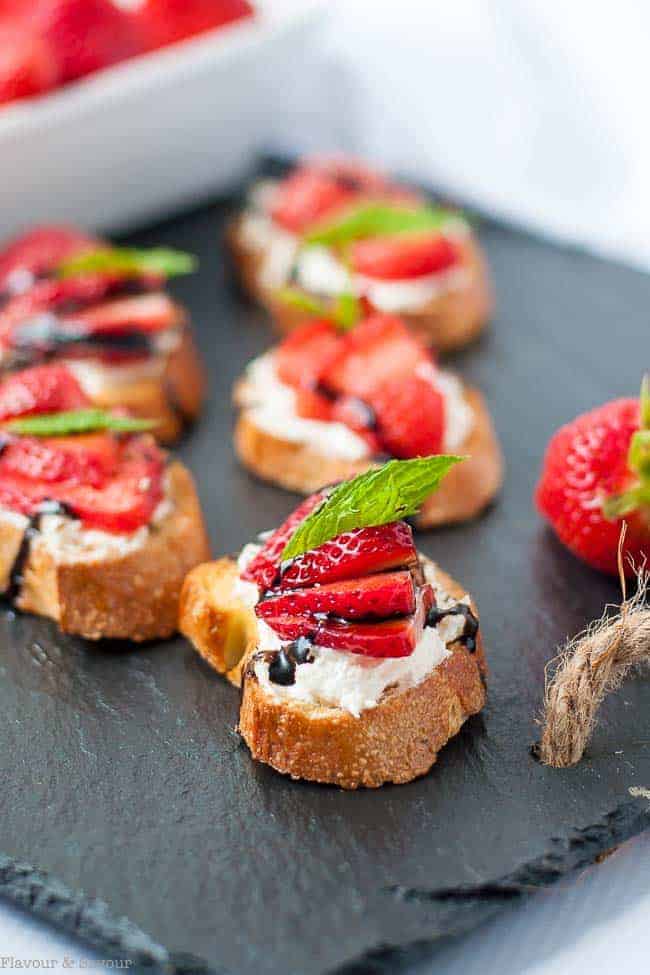 Strawberry Whipped Feta Crostini with Balsamic Drizzle on a slate board