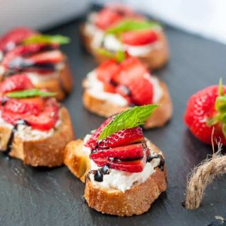 Strawberry Whipped Feta Crostini on a black slate board