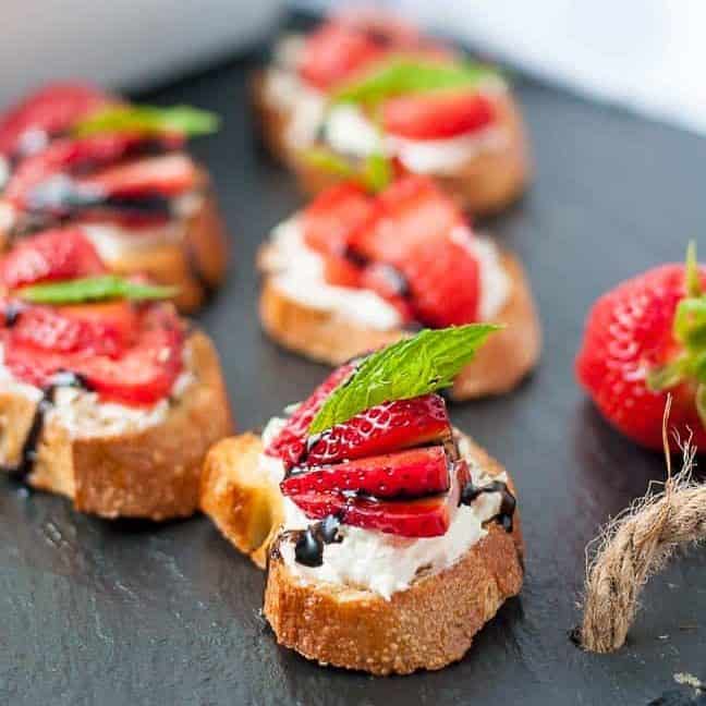 Strawberry Whipped Feta Crostini on a black slate board