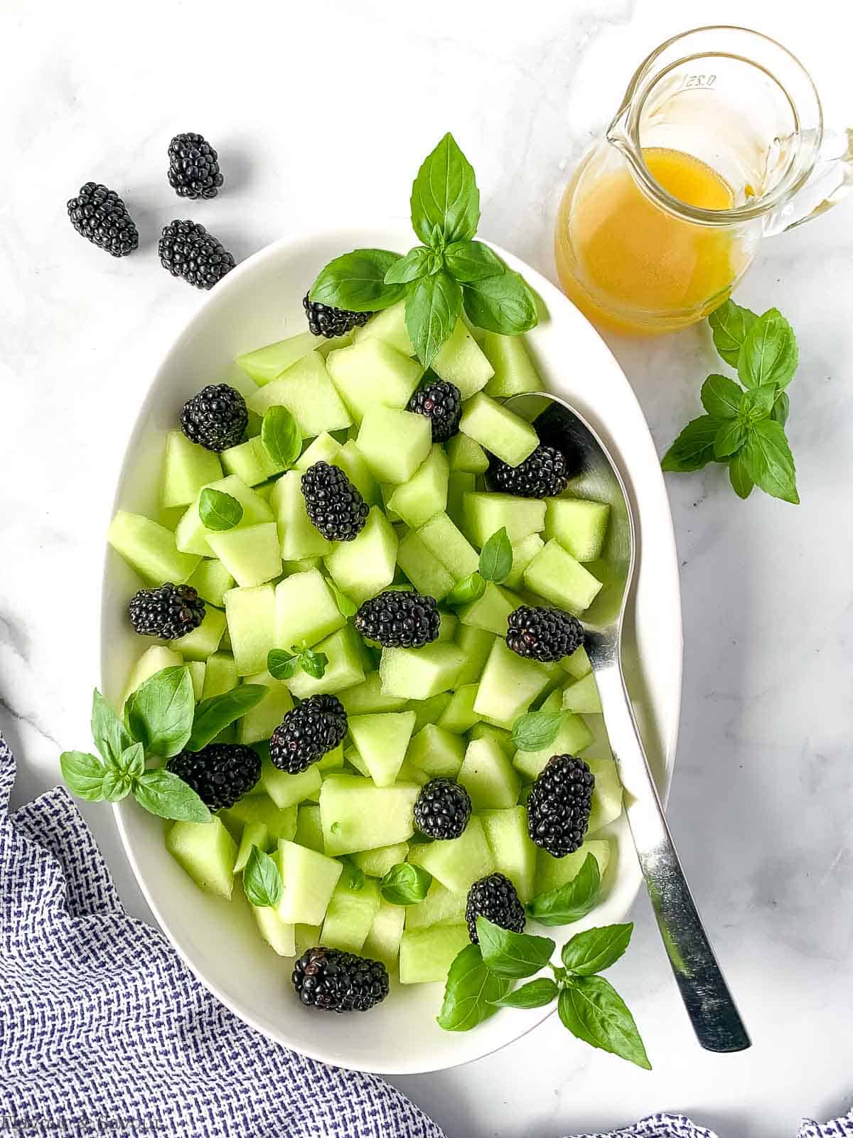 Blackberry Honeydew Salad with basil in an oval bowl.